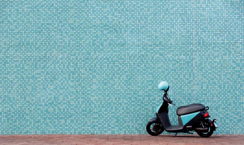 Scooter rijder genieting voordelen van scooterrijden met wind in haren op open weg
